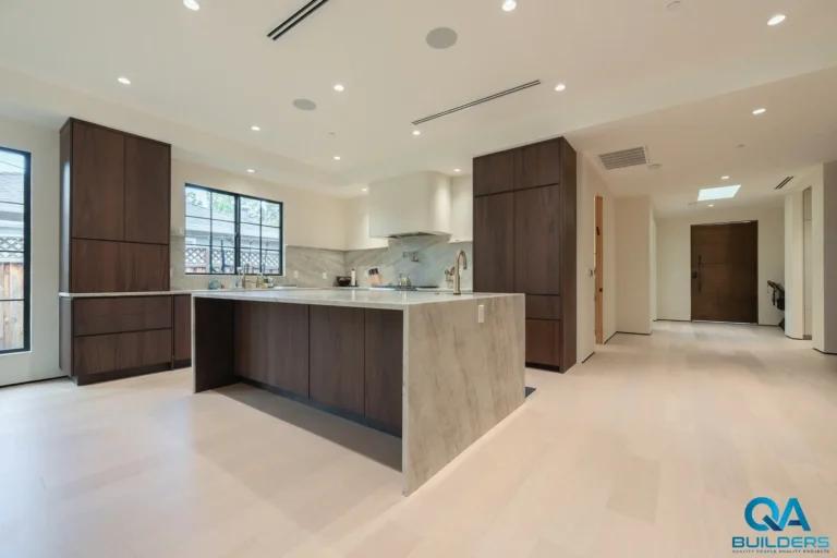 Open kitchen with dark wood cabinets and a stone waterfall island, San Jose