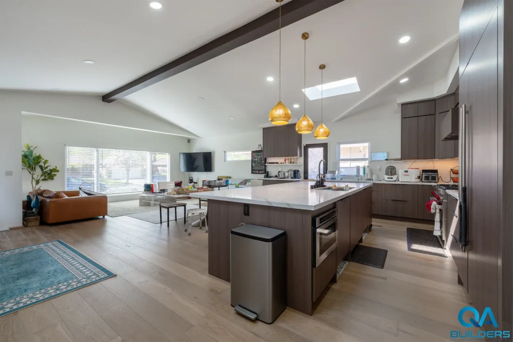 Kitchen island with a stone top and gold pendants in the open-plan addition, San Jose