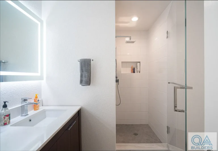 White vanity and walk-in shower with white tile and a glass door, Santa Clara