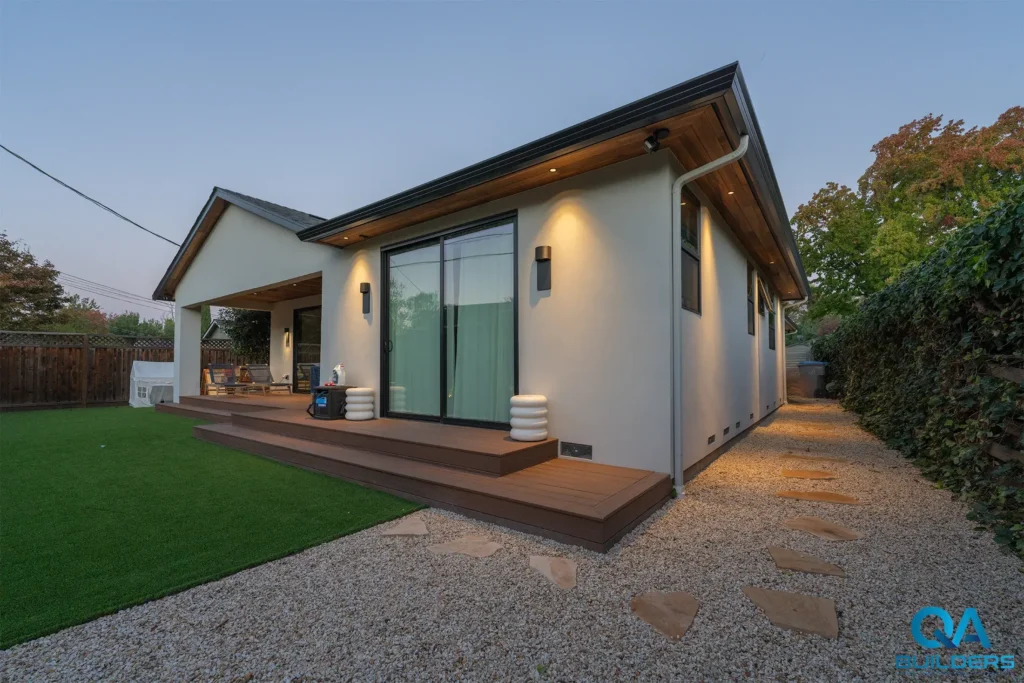Rear of the new home with a covered wood deck and large sliding door, San Jose