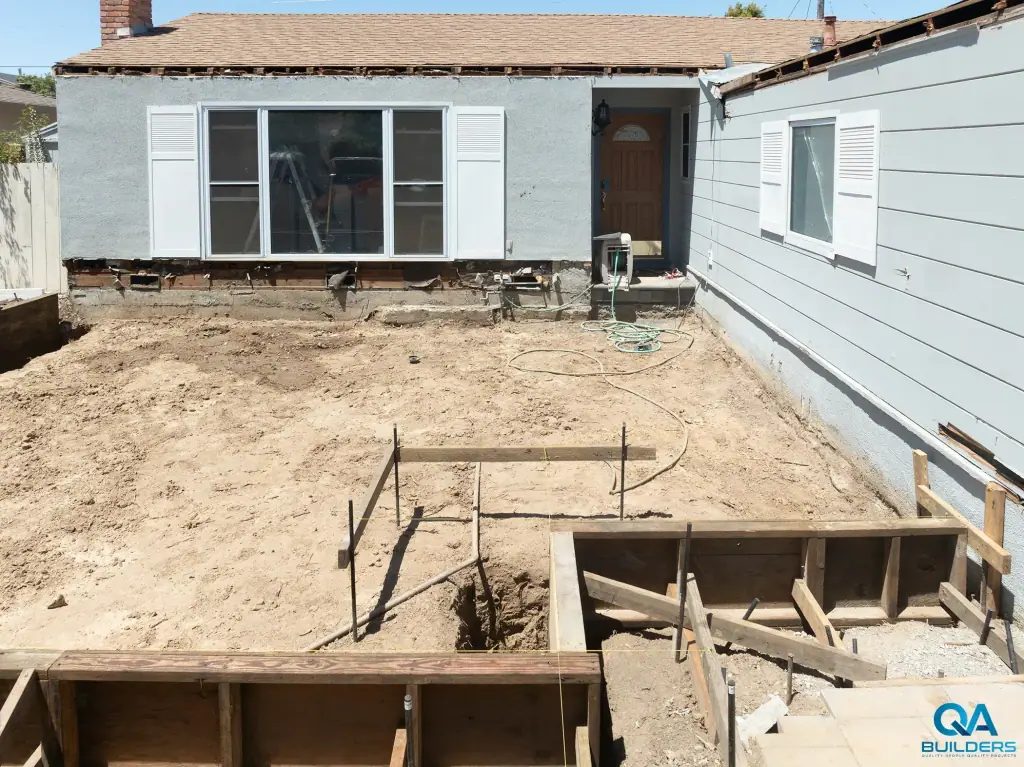 Wooden foundation forms and an open trench for a front addition on a single-story San Jose house