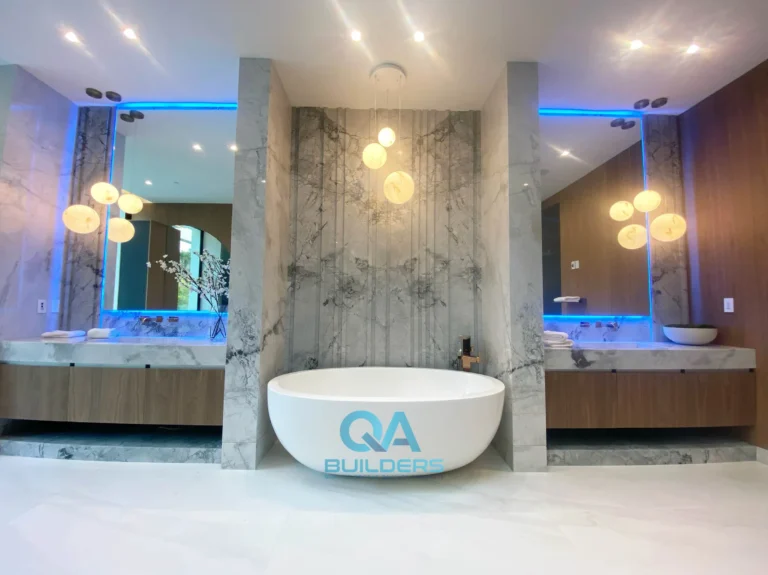 Luxury master bathroom with freestanding tub between stone slab walls
