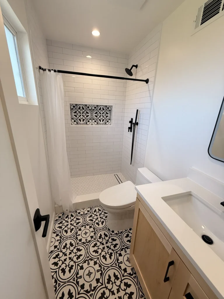 Remodeled San Jose bathroom with patterned floor tile, light wood vanity and a walk-in shower