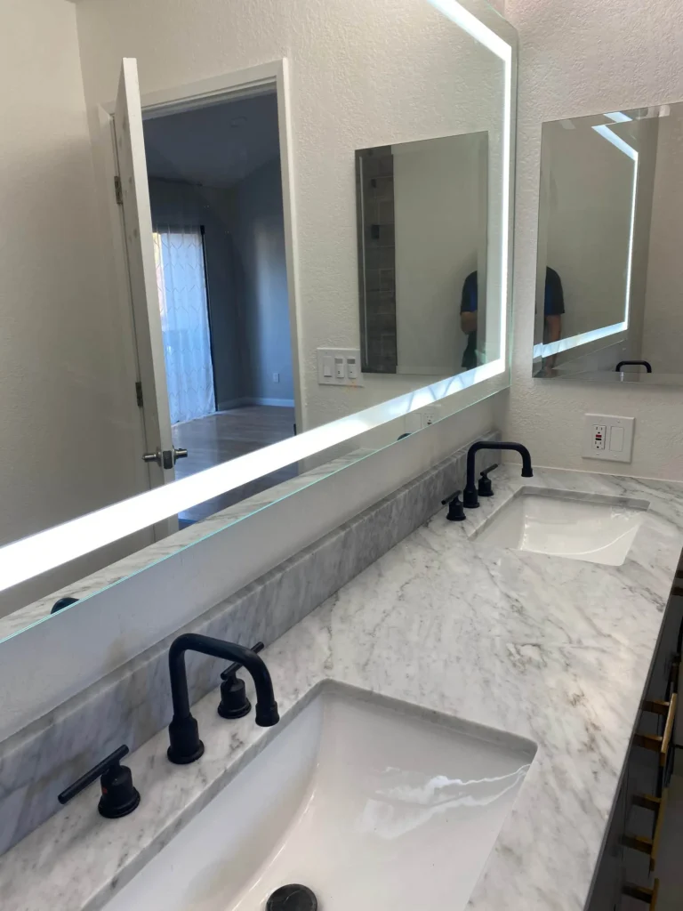 Marble vanity top with matte black faucet and backlit mirror in Sunnyvale