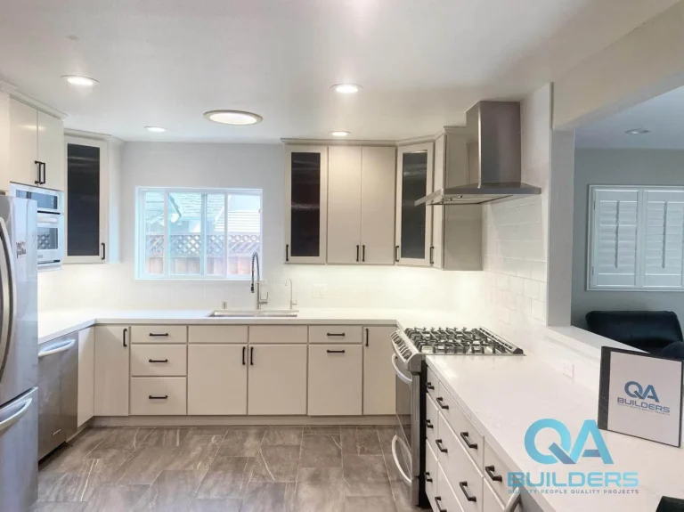 Refinished kitchen cabinets with new white counters and subway backsplash