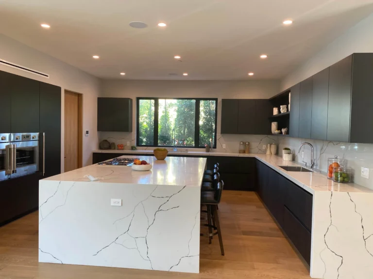 Modern kitchen remodel with matte black cabinets and white waterfall island