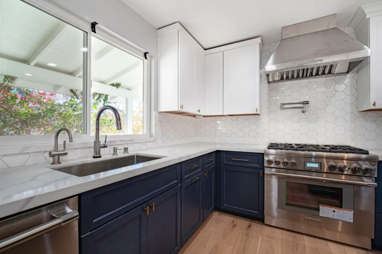 Open-concept kitchen remodel with navy cabinets and hexagon tile backsplash
