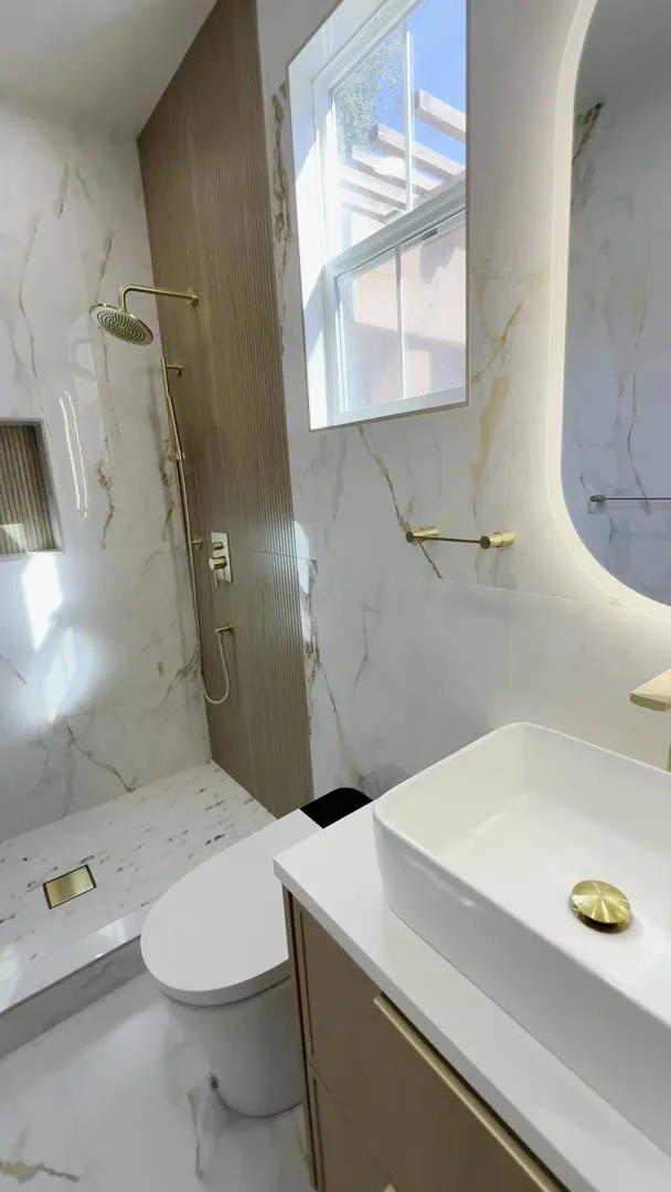Marble-look bathroom with brushed-gold fixtures in San Jose